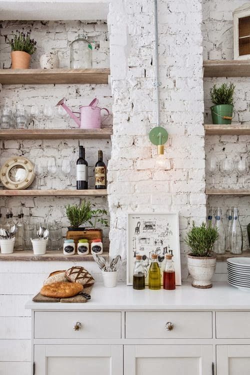 there are two pictures of a kitchen with white walls and open shelves on the wall