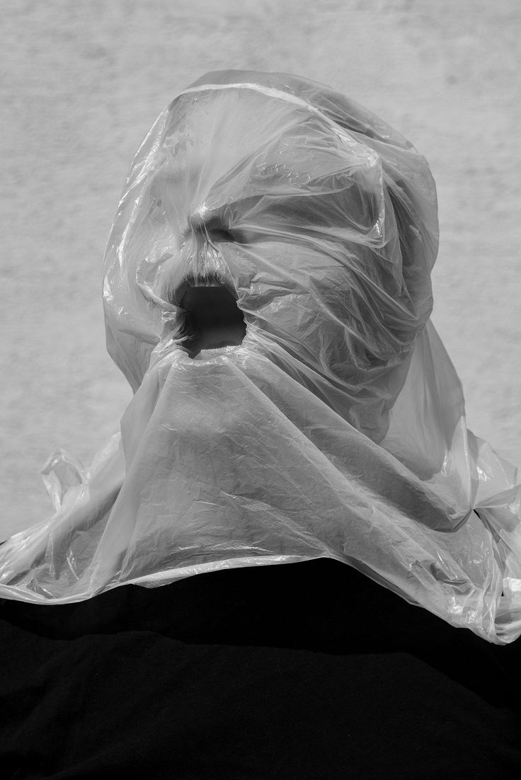 a black and white photo of a person wearing a plastic bag over their head,