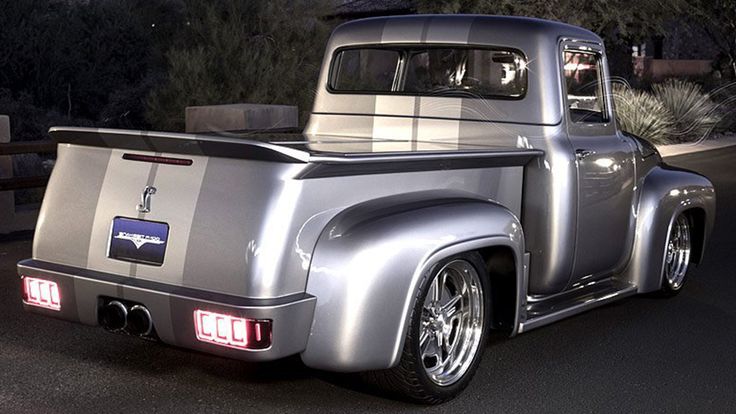 an old silver truck parked on the street at night