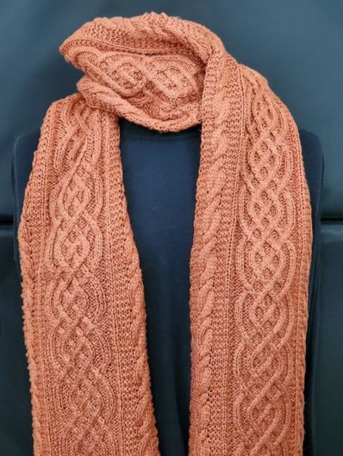 an orange knitted scarf sitting on top of a blue chair