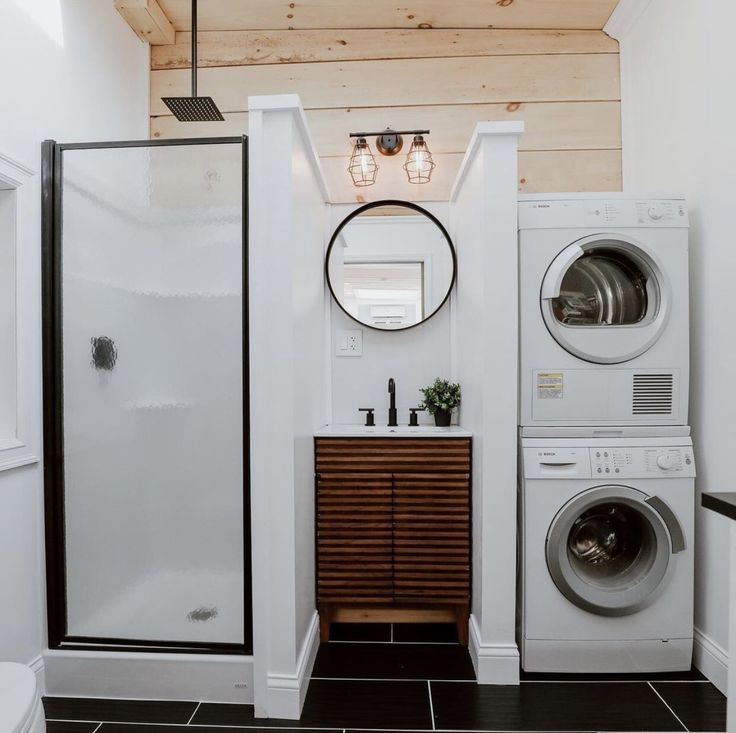 a washer and dryer in a bathroom with wood paneling on the ceiling