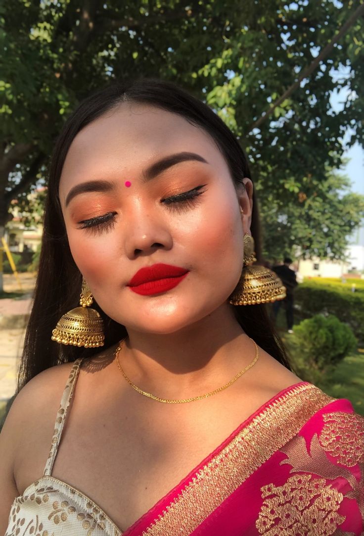 Pink bindi with a nude golden eye and classic red lip for a wedding guest makeuplook Red Lips Indian Makeup, Red Lip Makeup Look Indian, Red Lip Indian Makeup, Golden Saree Makeup Look, Red Saree Makeup Look, Red And Gold Makeup Looks, Red And Gold Makeup, Indian Wedding Guest Makeup, Makeup Looks Indian