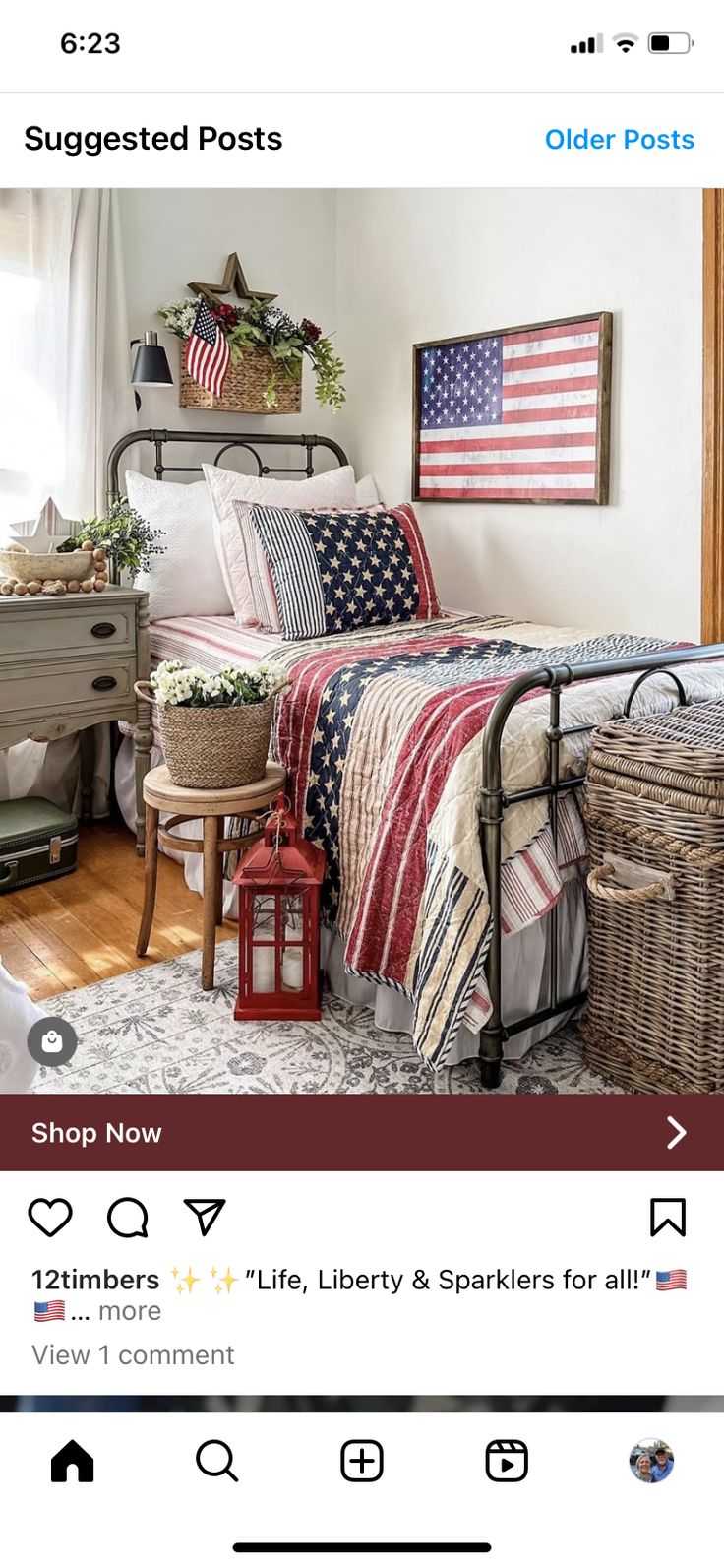 a bed with an american flag quilt on it and two baskets next to the bed