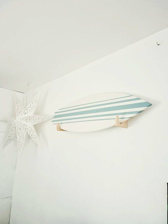 a surfboard mounted to the side of a white wall next to a starfish