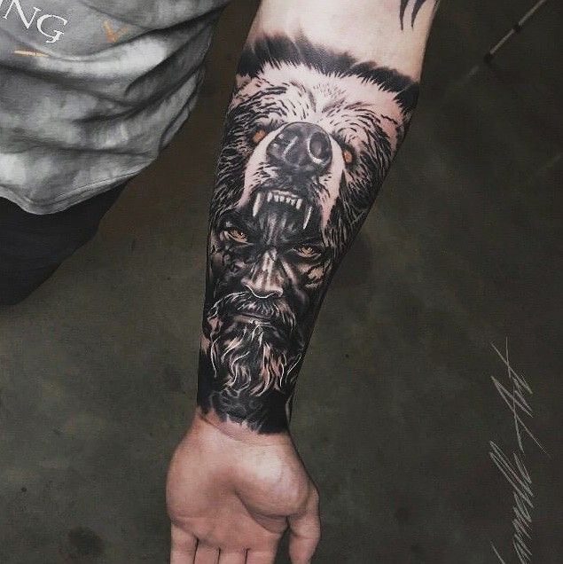 a man's arm with a bear and wolf tattoo on his left hand,