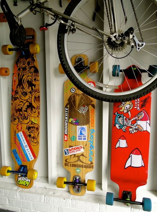 several skateboards are hanging on the wall next to a bicycle tire and bike wheel