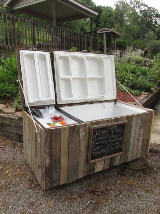 an ice chest made out of pallet wood with chalkboard writing on the side