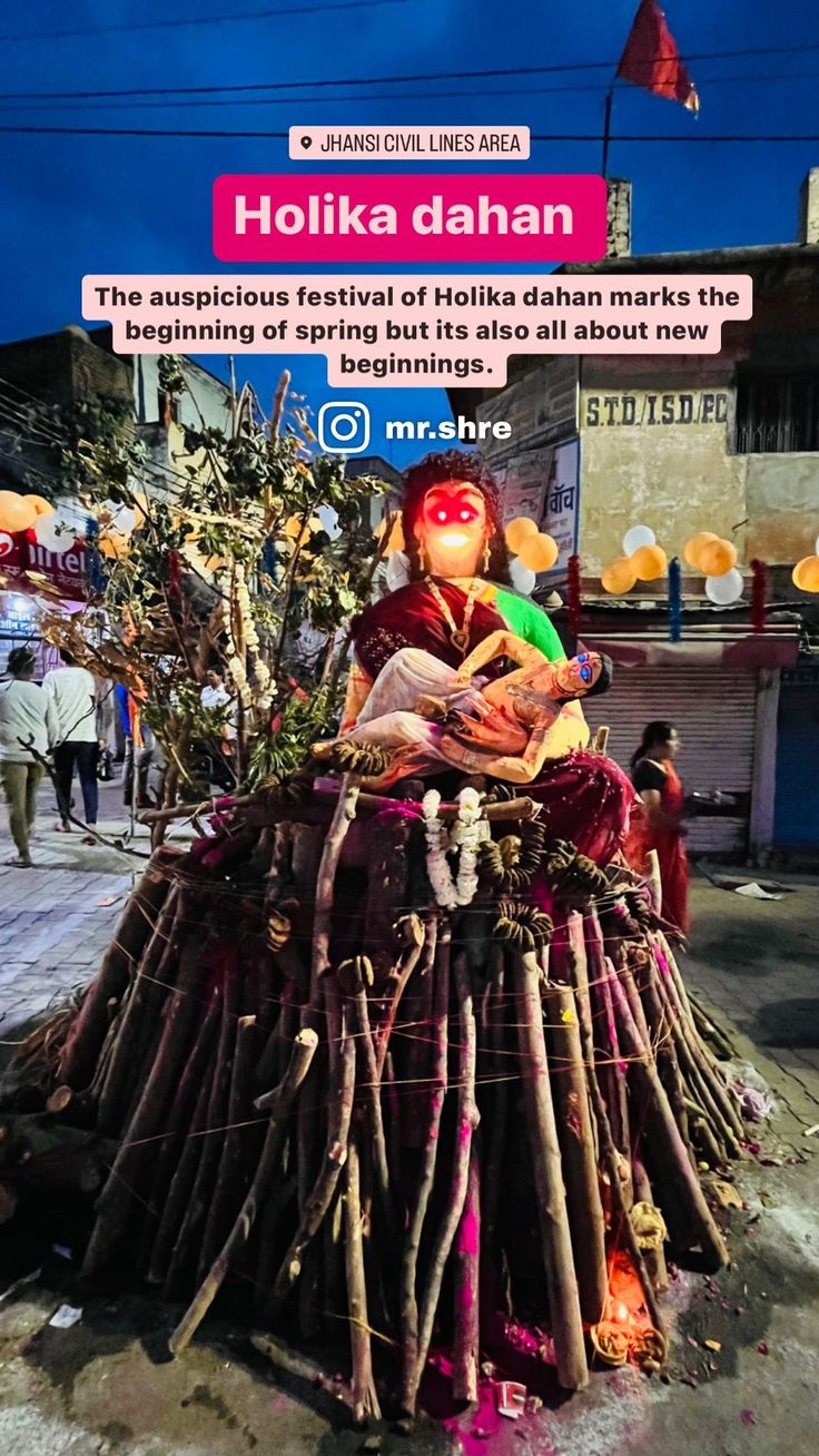 there is a statue made out of sticks and other items on the street with a sign in the background