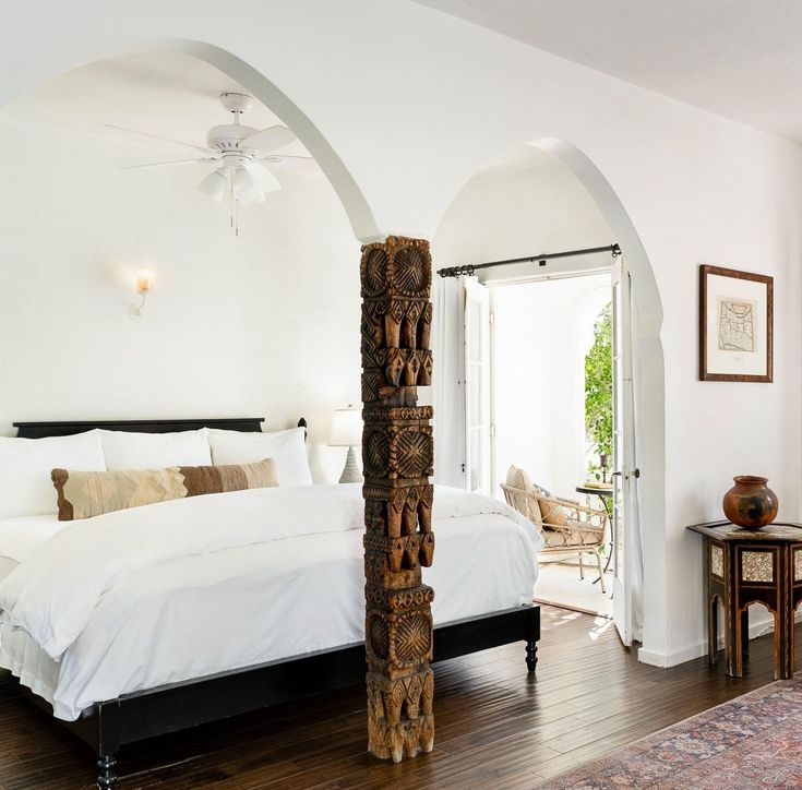 a large bed sitting inside of a bedroom on top of a hard wood floor