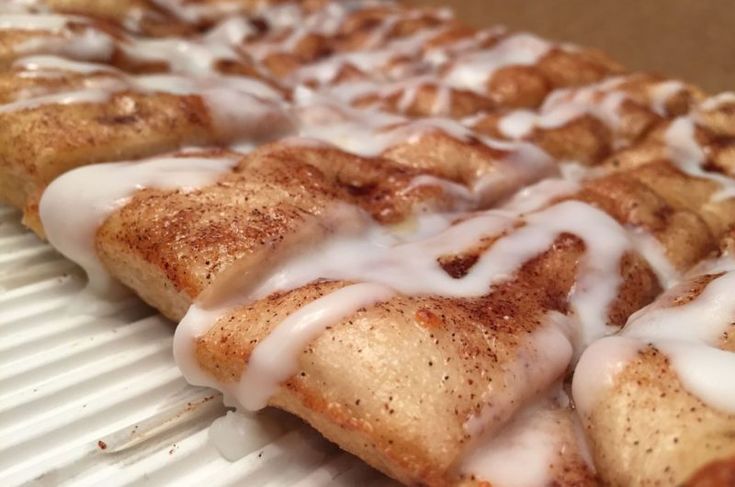 cinnamon roll with icing on top sitting in a box