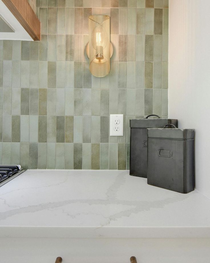 a stove top oven sitting inside of a kitchen next to a wall mounted light fixture