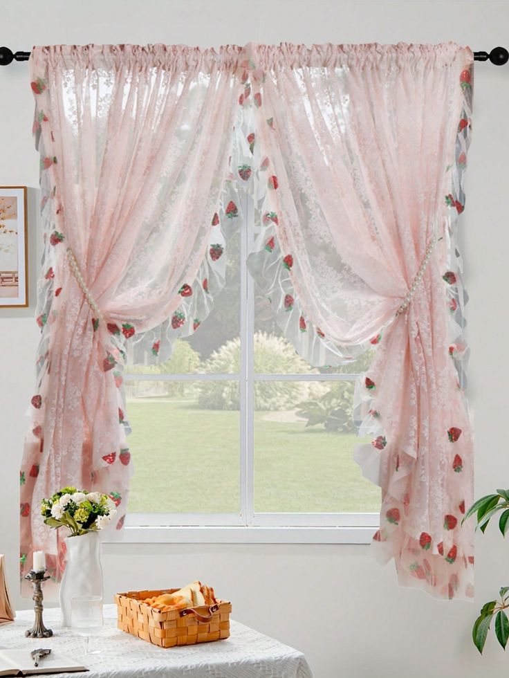 a white table topped with a vase filled with flowers next to a window covered in sheer curtains