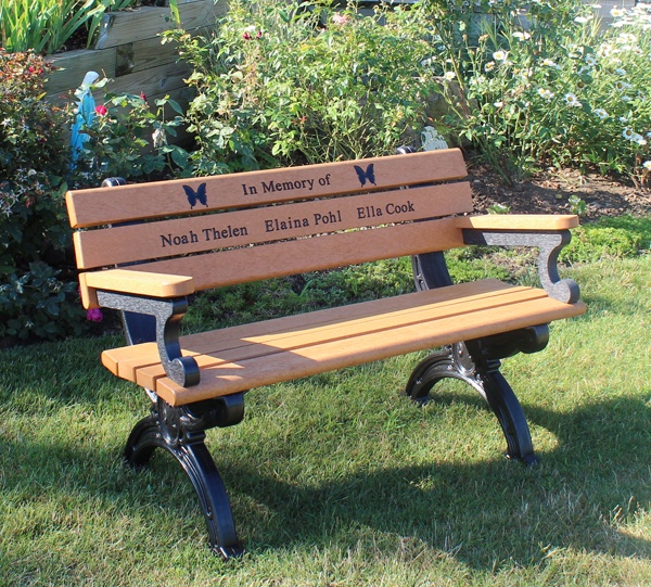 a wooden bench sitting on top of a lush green field