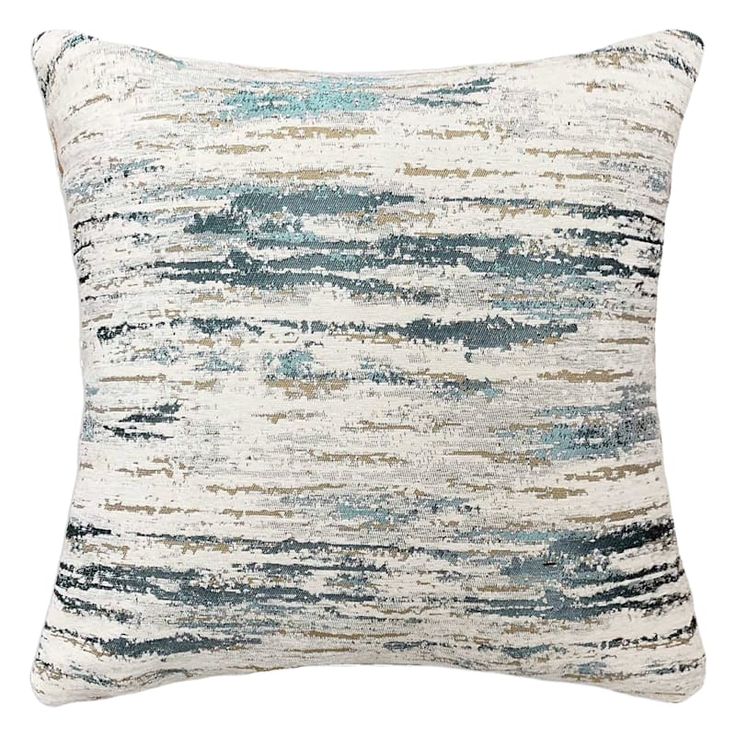 a white and blue pillow with an abstract design on the front, in shades of green