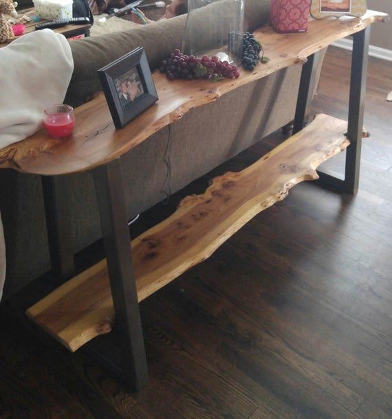 a wooden table sitting on top of a hard wood floor next to a couch in a living room