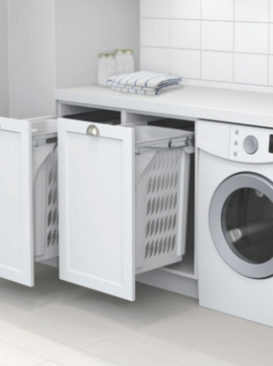 a washer and dryer in a small room with white tile flooring on the walls