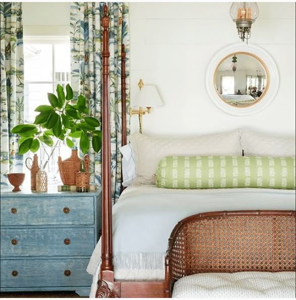 a bed sitting in a bedroom next to a dresser with a mirror on top of it