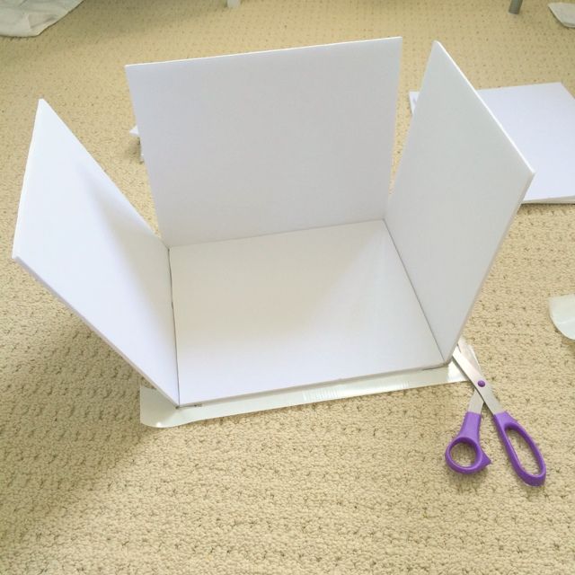 a pair of scissors sitting on top of a white piece of paper next to a cut out box