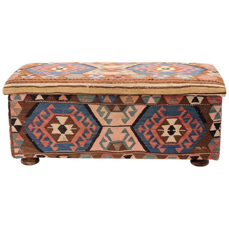 an old box with colorful designs on the lid and legs, sitting on a white background