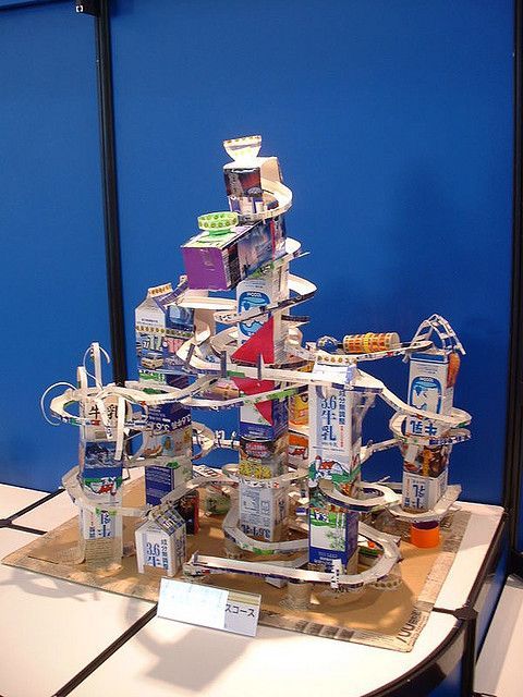 a christmas tree made out of books and magazines on a table in front of a blue wall