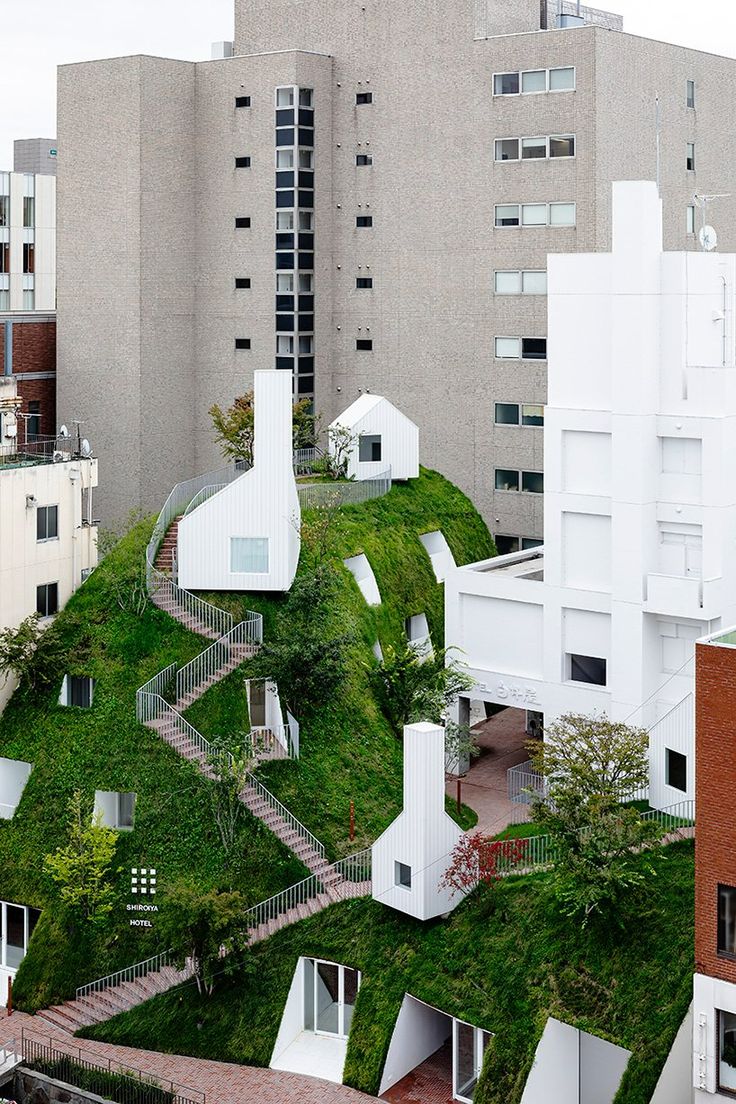 an aerial view of a building with grass on the roof and stairs leading up to it