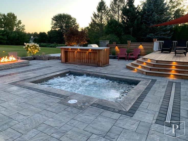 a hot tub sitting on top of a patio next to a fire pit