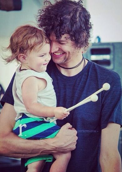 a man holding a small child with a baseball bat