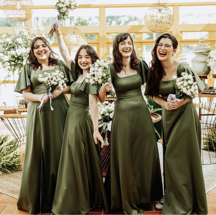 the bridesmaids are all wearing green dresses and holding bouquets in their hands