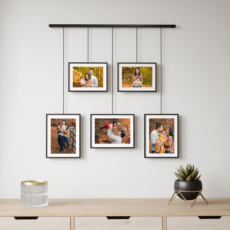 four frames hanging on the wall above a dresser with a potted plant next to it