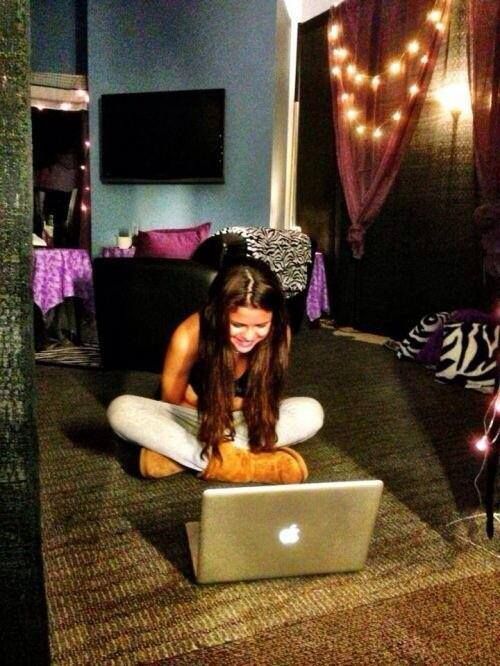 a woman is sitting on the floor with her laptop