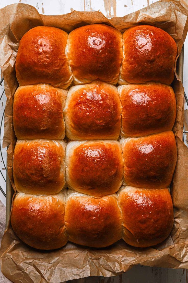 a pan filled with hot cross buns sitting on top of a wooden table next to a wire rack