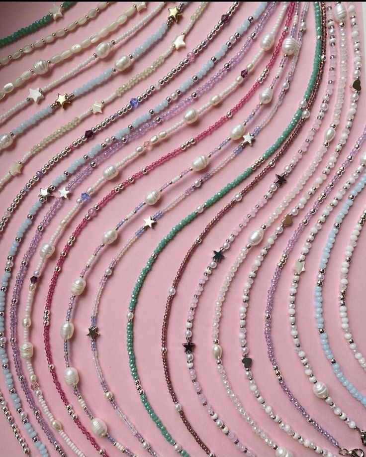 a bunch of necklaces that are laying on a table with pearls and other beads