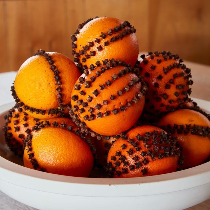 oranges with chocolate sprinkles in a white bowl on a wooden table