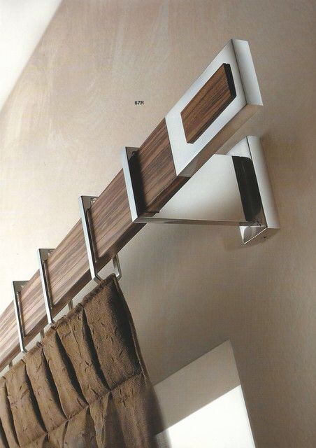 a close up of a mirror on the wall above a shelf with wood and metal accents