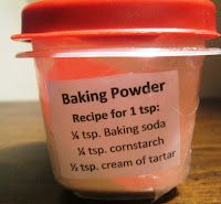 a jar filled with baking powder sitting on top of a wooden table next to a red lid