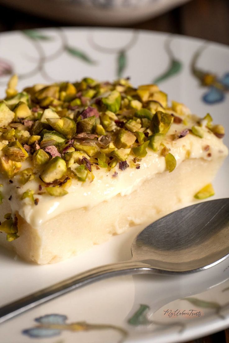 a piece of cake sitting on top of a white plate next to a silver spoon