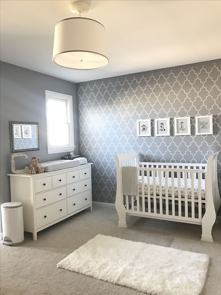 a baby's room with grey and white wallpaper