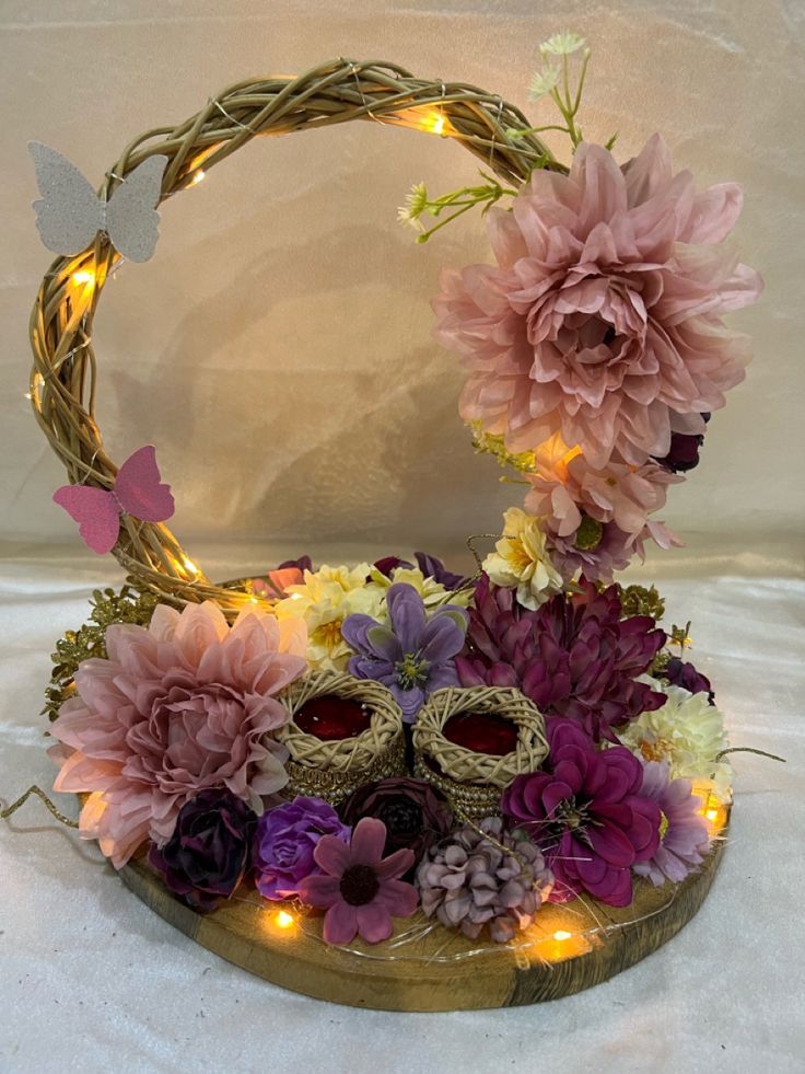 a basket filled with flowers and lights on top of a table