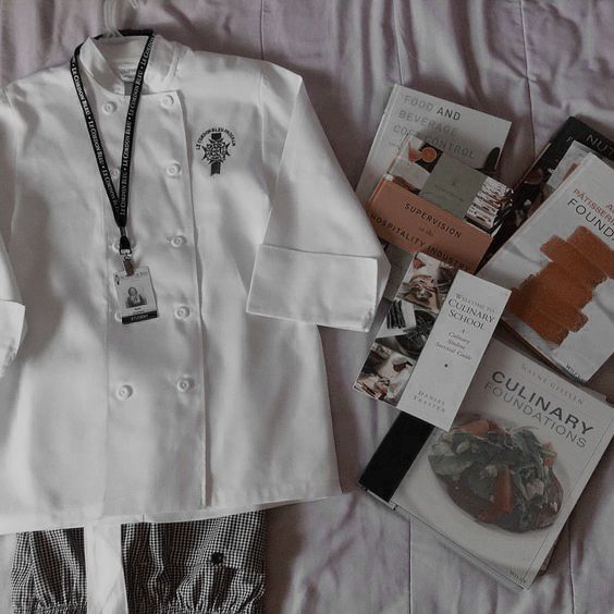 a white jacket and some books on top of a bed next to a blue lanyard