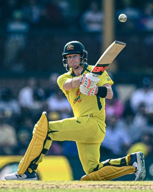 a man in yellow uniform playing a game of cricket