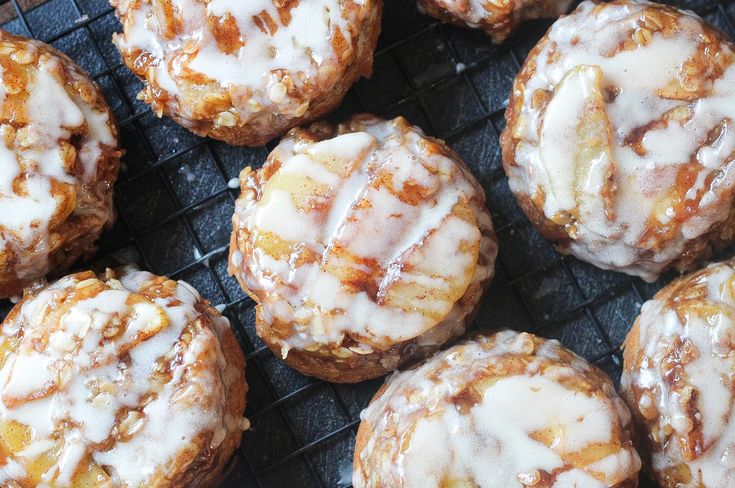 there are many donuts that have icing on top of them, sitting on a cooling rack