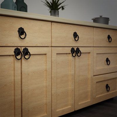 a kitchen with wooden cabinets and black handles