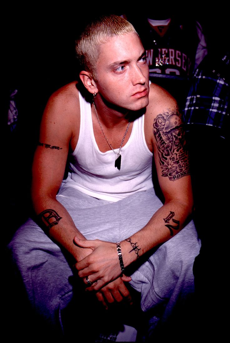 a man with tattoos on his arm sitting down