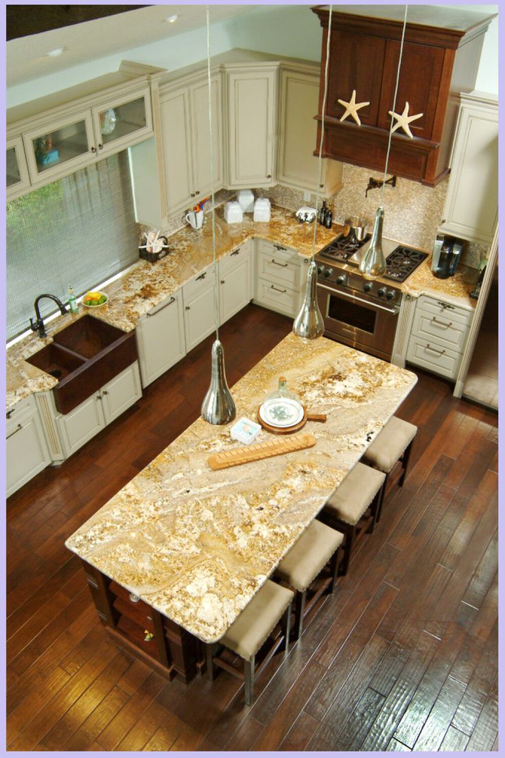 an aerial view of a kitchen with wooden floors and granite counter tops, along with stainless steel appliances