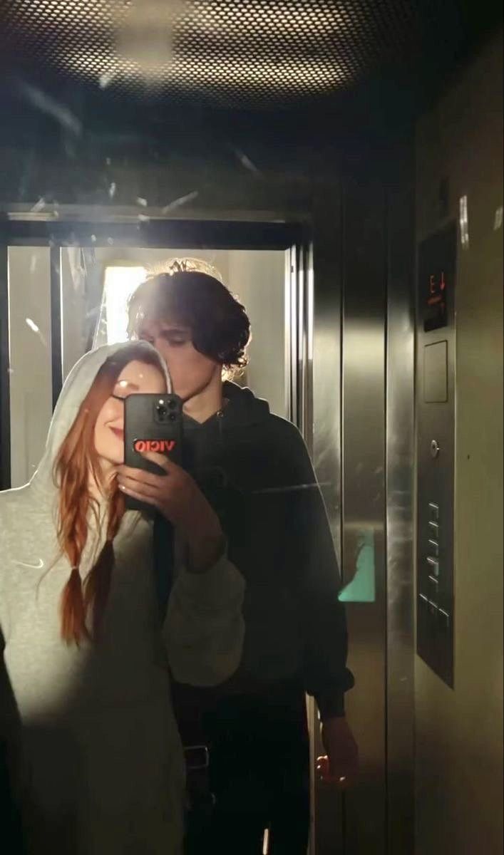 a man and woman are taking a selfie in the mirror while standing next to each other