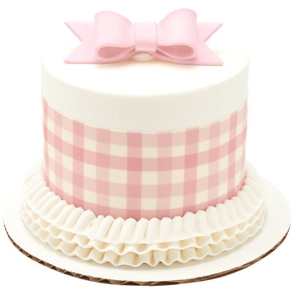 a pink and white checkered cake with a bow on top, sitting on a plate