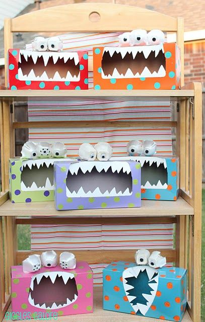 cardboard monster boxes are stacked on top of each other in front of a wooden shelf