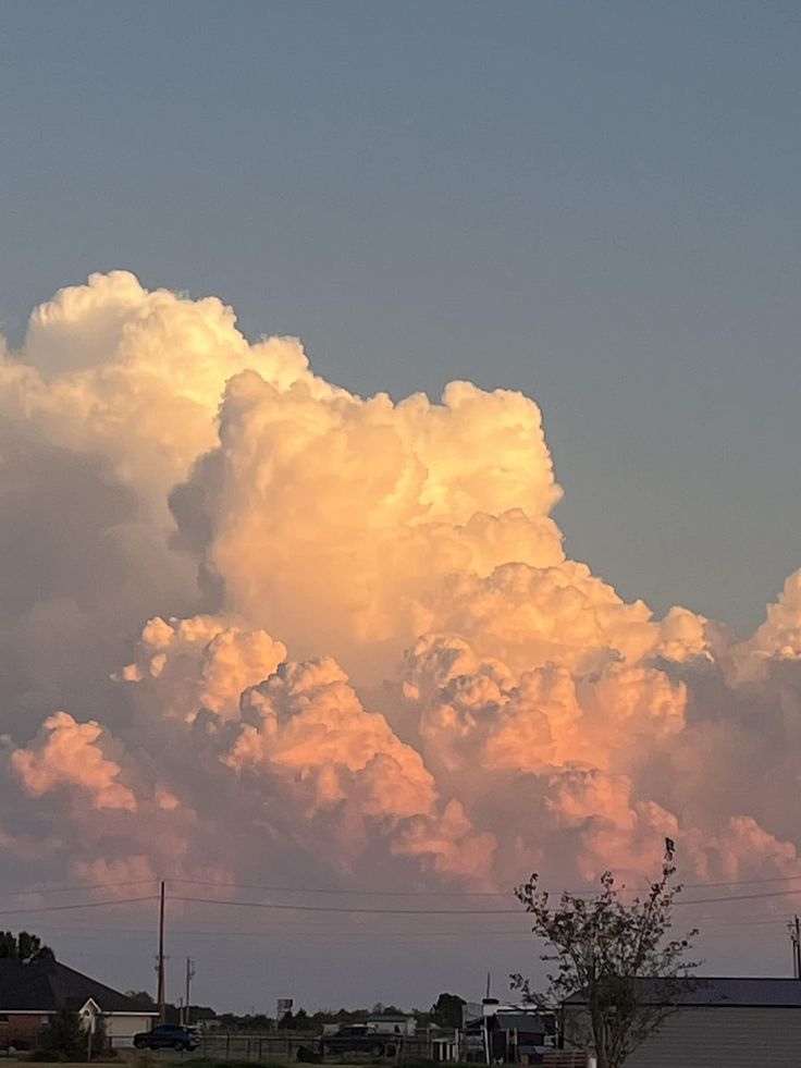 a large cloud is in the sky above some houses