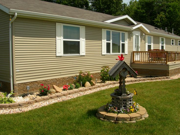 a home with landscaping in front of it and a mailbox on the side of the house