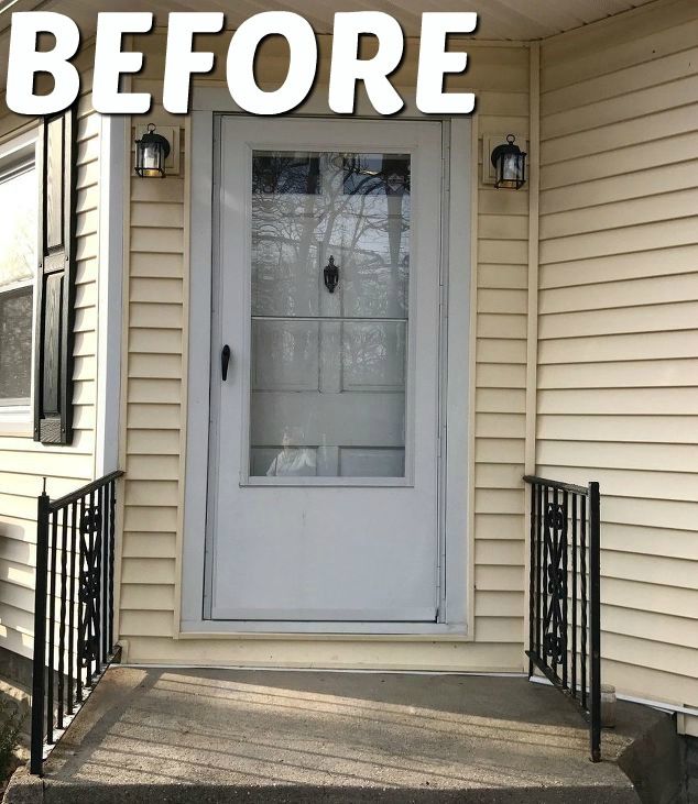 the front door of a house with black iron railings and glass paneled doors